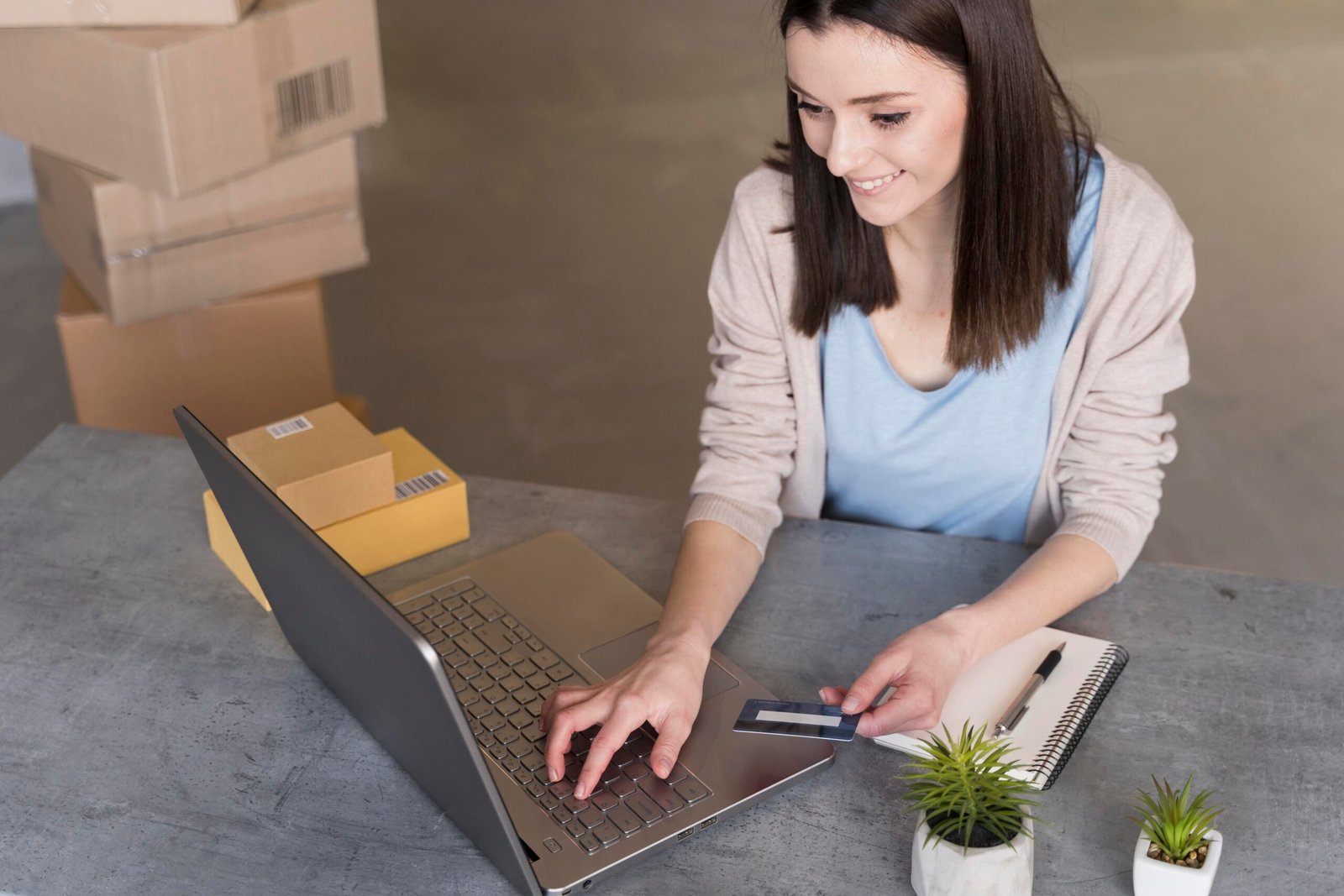 high angle woman working with laptop boxes